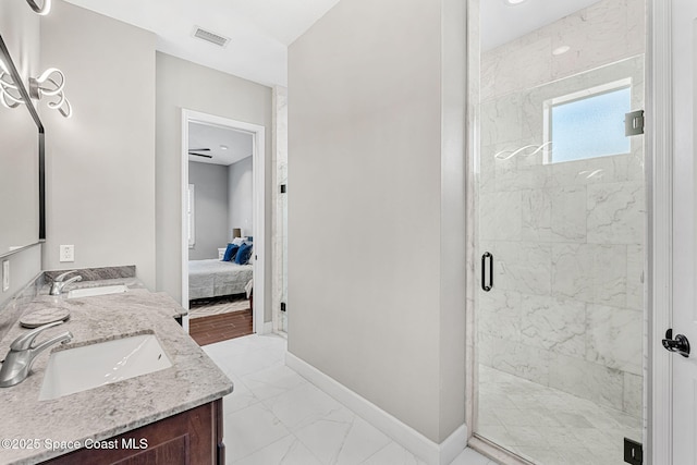 ensuite bathroom featuring marble finish floor, a shower stall, baseboards, and a sink