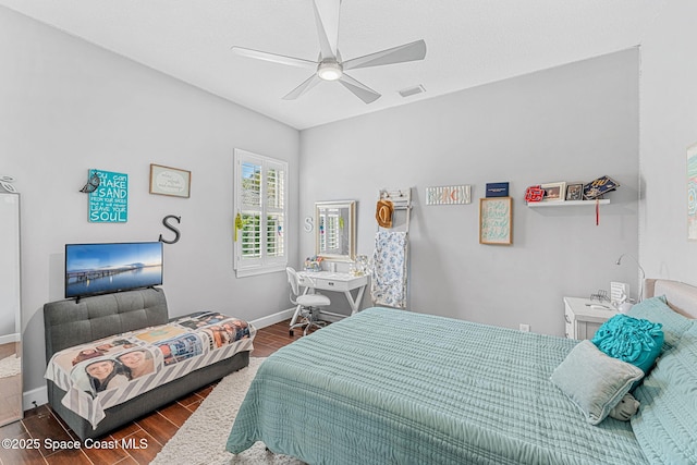 bedroom featuring visible vents, a ceiling fan, baseboards, and wood finished floors