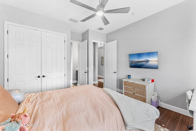 bedroom featuring dark wood-type flooring, baseboards, visible vents, and a closet