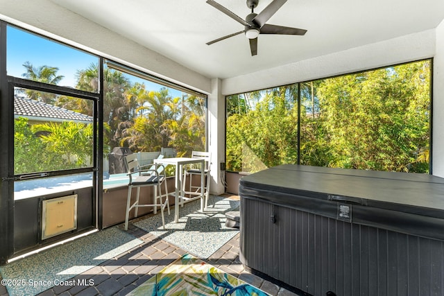 unfurnished sunroom featuring ceiling fan