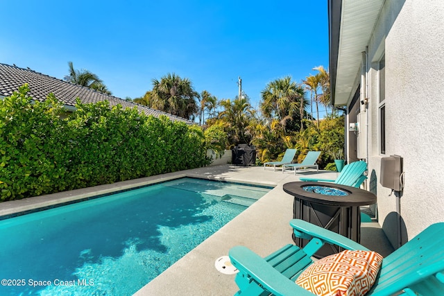 view of pool with a patio area, a fenced in pool, a fire pit, and a fenced backyard