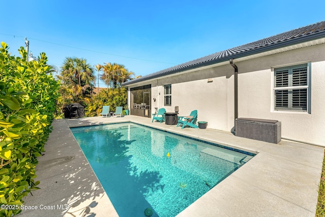 outdoor pool featuring a patio area and a sunroom