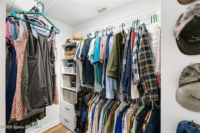 walk in closet featuring visible vents and wood finished floors