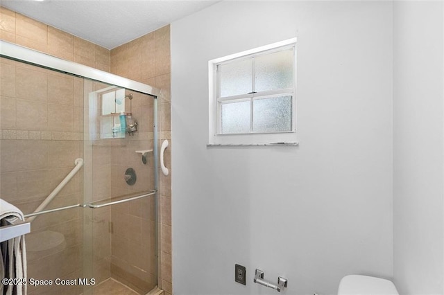 bathroom with a shower stall and toilet