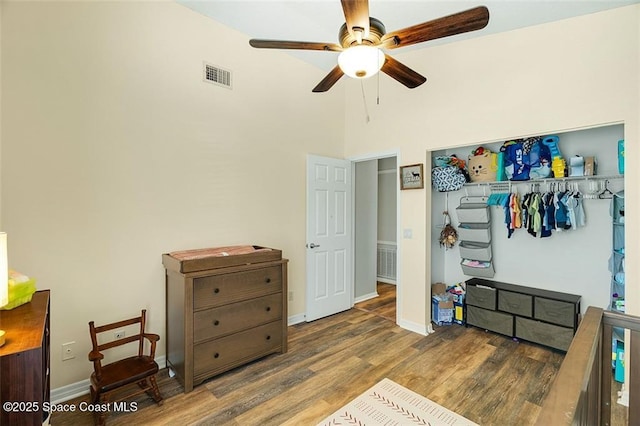 bedroom featuring visible vents, baseboards, a closet, and wood finished floors