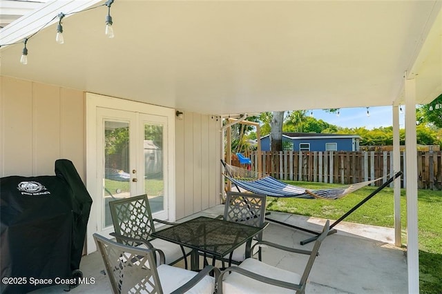 view of patio / terrace with area for grilling, french doors, and fence