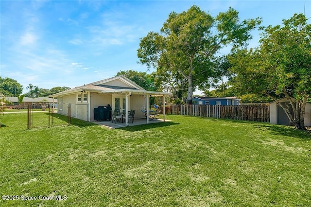 view of yard featuring an outbuilding, a gate, a fenced backyard, a storage shed, and a patio area