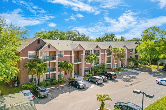 view of property with uncovered parking and a residential view
