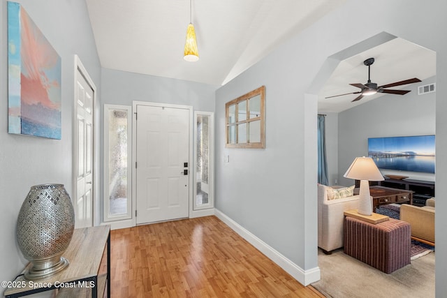 entryway featuring baseboards, lofted ceiling, light wood finished floors, and a ceiling fan