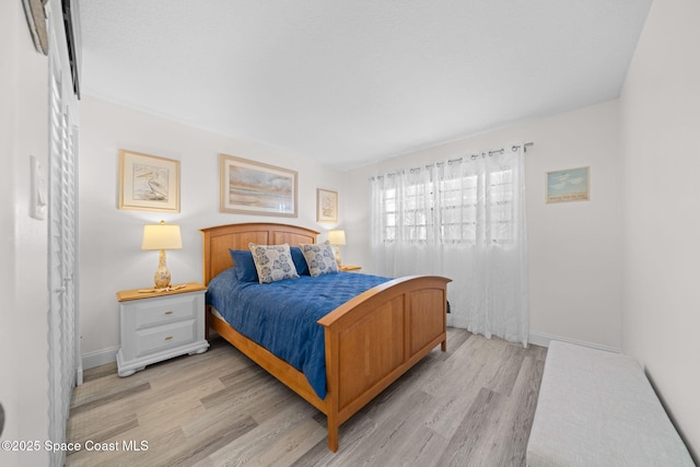 bedroom featuring light wood-type flooring and baseboards