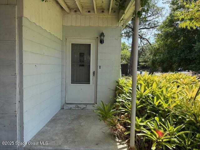 doorway to property featuring concrete block siding