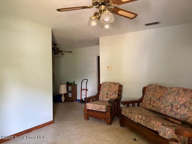 living area featuring visible vents, baseboards, and a ceiling fan