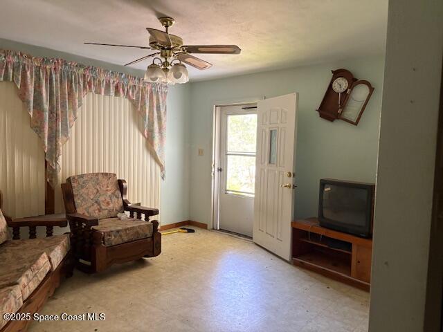 sitting room featuring tile patterned floors and ceiling fan