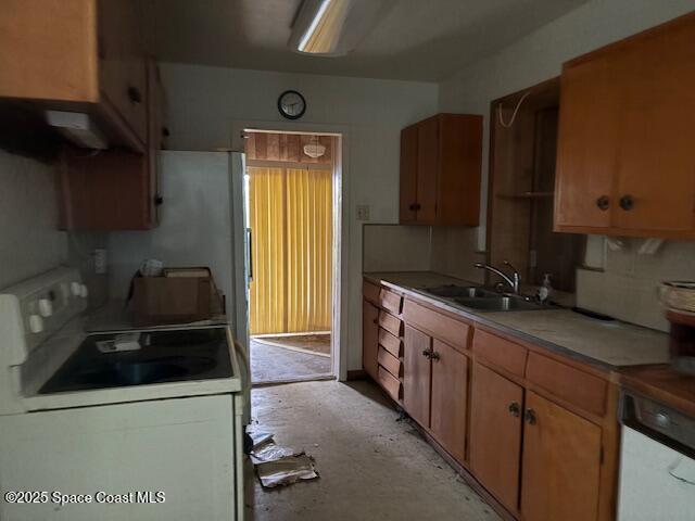 kitchen with light countertops, electric range, and a sink