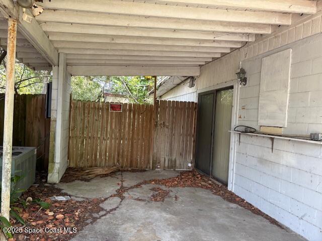 view of patio / terrace featuring a carport, central AC, and fence