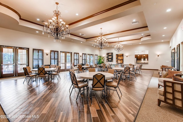 dining area featuring a notable chandelier and a raised ceiling