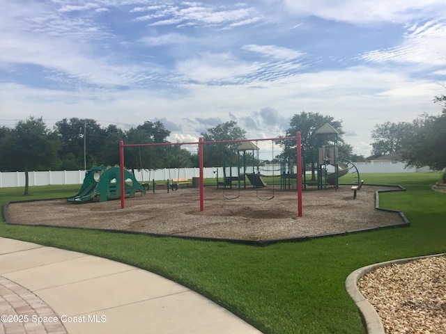 communal playground featuring fence and a lawn