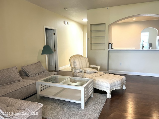 living area with arched walkways, recessed lighting, baseboards, and wood finished floors