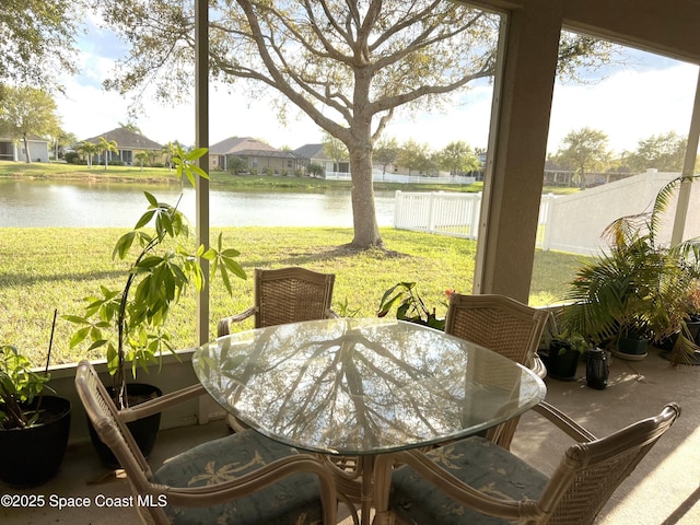 sunroom / solarium featuring a water view