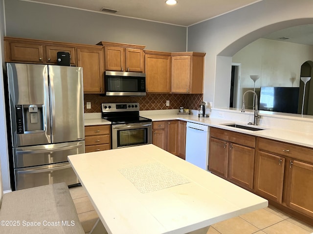 kitchen featuring visible vents, backsplash, appliances with stainless steel finishes, light tile patterned flooring, and a sink