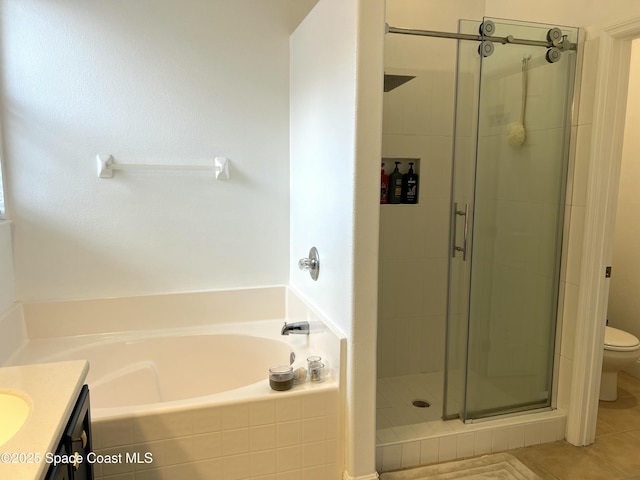 full bath featuring tile patterned floors, toilet, a stall shower, a bath, and vanity