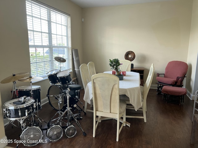 dining space with baseboards and wood finished floors