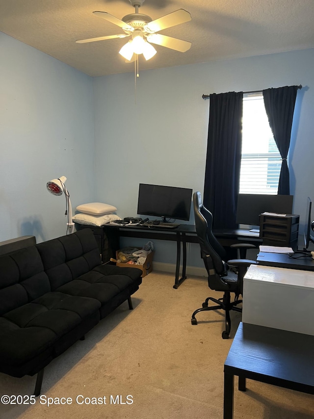 home office featuring a ceiling fan, carpet floors, and a textured ceiling