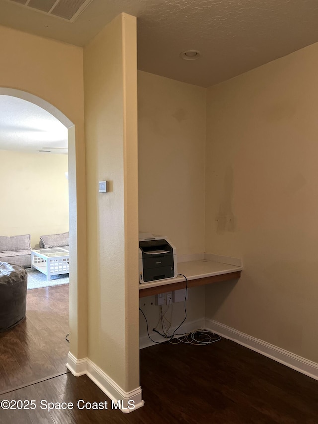 home office featuring visible vents, wood finished floors, arched walkways, and baseboards