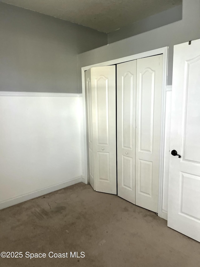 unfurnished bedroom with a closet and carpet