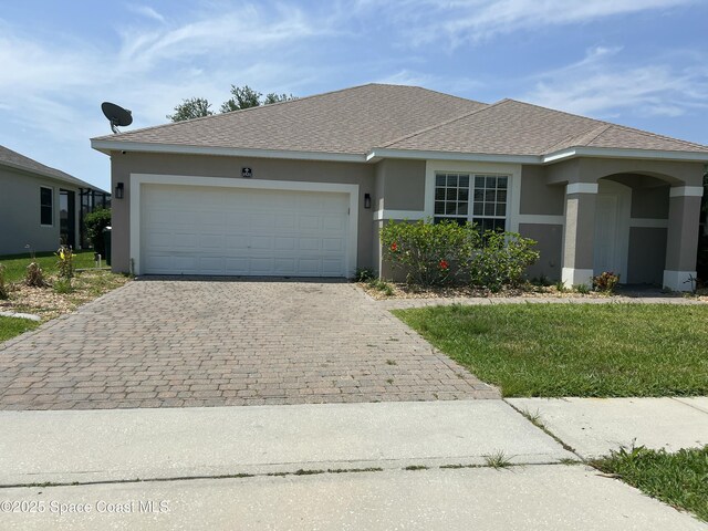view of front facade with stucco siding, decorative driveway, an attached garage, and roof with shingles