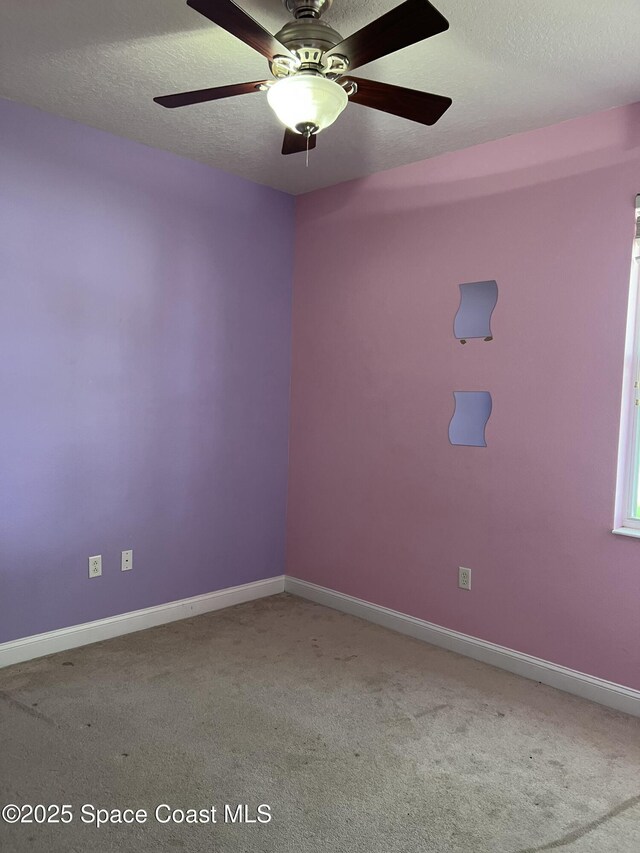 carpeted empty room with a textured ceiling, baseboards, and ceiling fan
