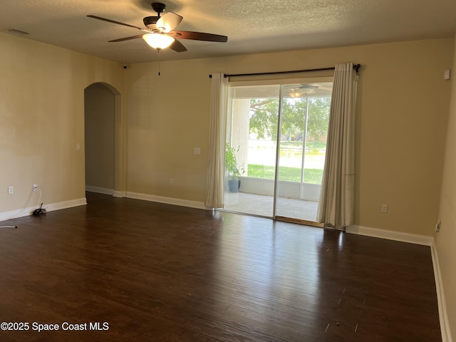 1521 Bridgeport Cir, Rockledge, FL 32955 - spare room featuring arched walkways, ceiling fan, dark wood-type flooring, baseboards, and a textured ceiling