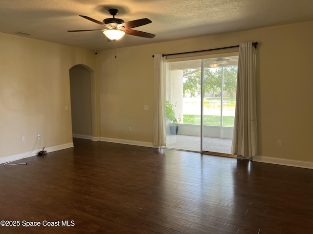 1521 Bridgeport Cir, Rockledge, FL 32955 - unfurnished room featuring arched walkways, a ceiling fan, dark wood-style floors, baseboards, and a textured ceiling