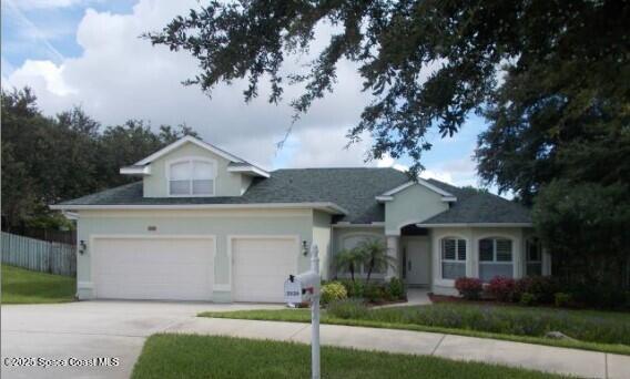 ranch-style home with stucco siding, an attached garage, driveway, and fence