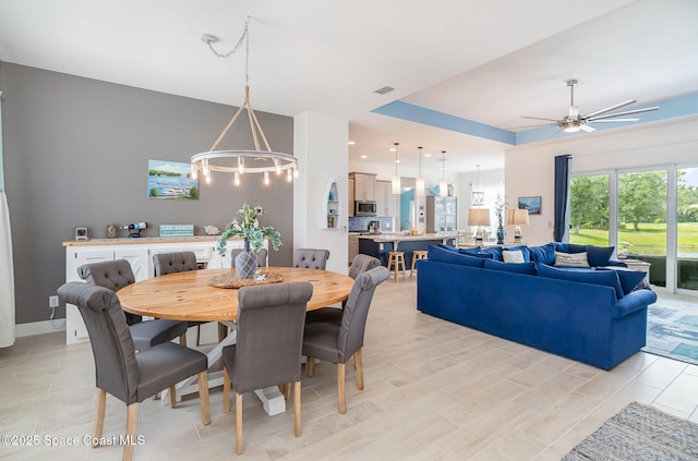 dining area with light wood finished floors, visible vents, baseboards, recessed lighting, and ceiling fan with notable chandelier