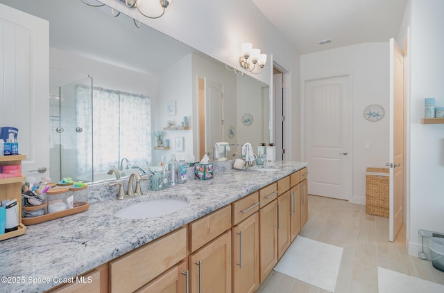 bathroom featuring double vanity, visible vents, a shower stall, and a sink