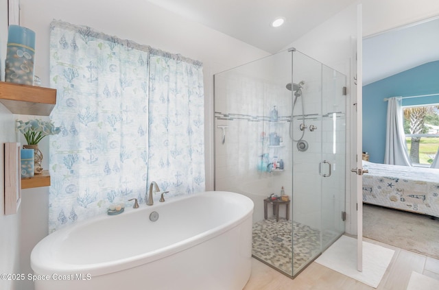 ensuite bathroom with lofted ceiling, recessed lighting, a stall shower, ensuite bathroom, and a soaking tub