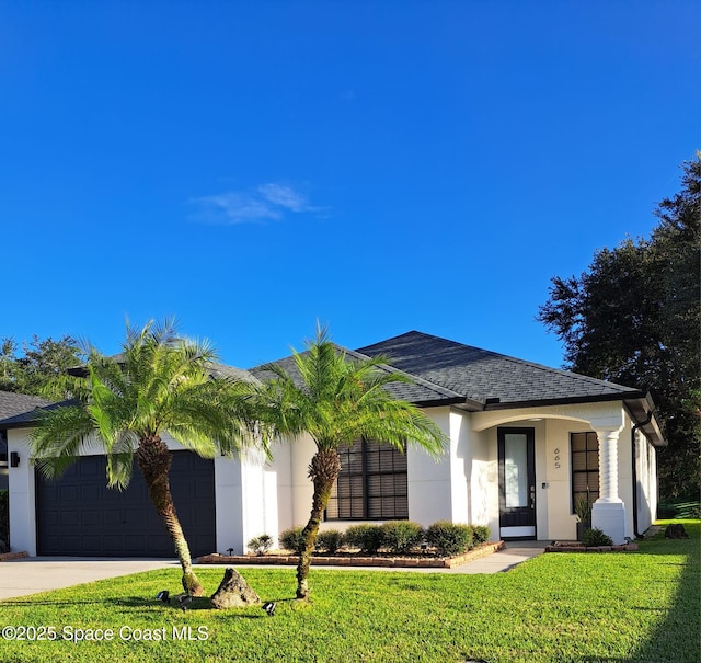 view of front facade featuring stucco siding, driveway, a front lawn, roof with shingles, and an attached garage