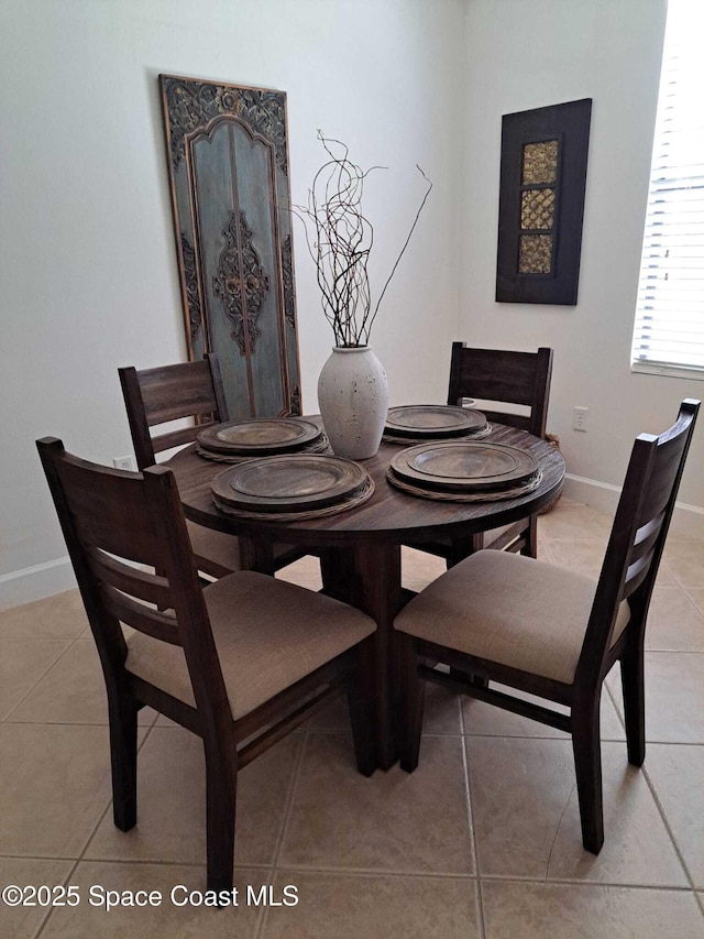 dining space featuring light tile patterned floors and baseboards