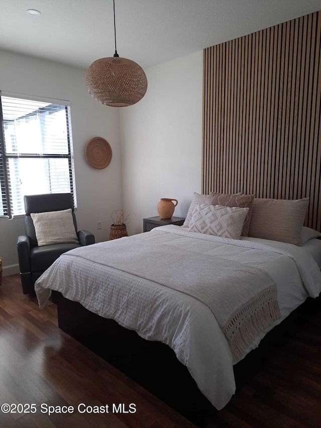 bedroom with baseboards and wood finished floors