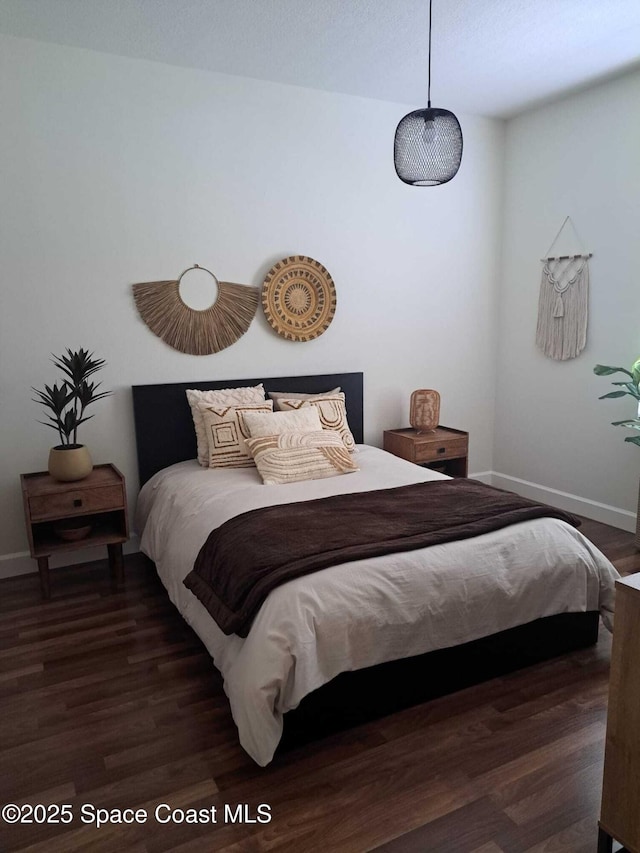 bedroom with baseboards and wood finished floors