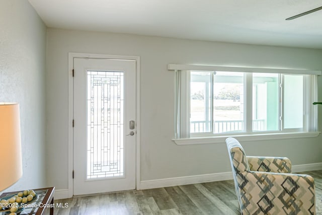 foyer entrance with ceiling fan, baseboards, and wood finished floors