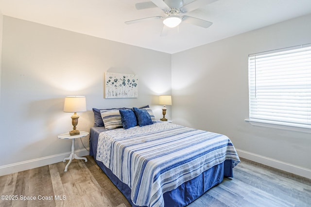 bedroom featuring a ceiling fan, baseboards, and wood finished floors