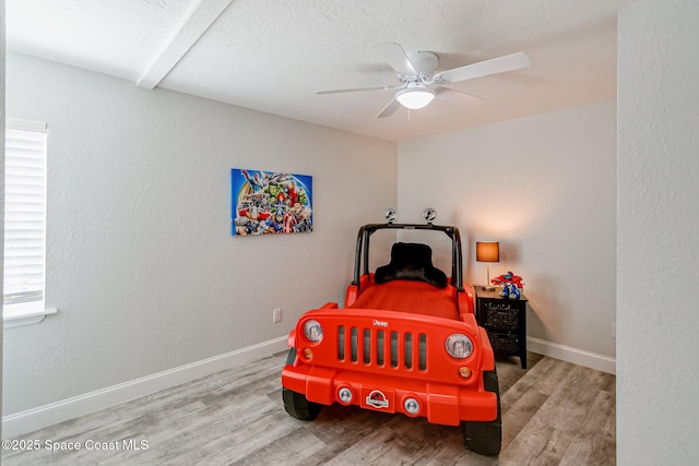 bedroom featuring ceiling fan, baseboards, and wood finished floors