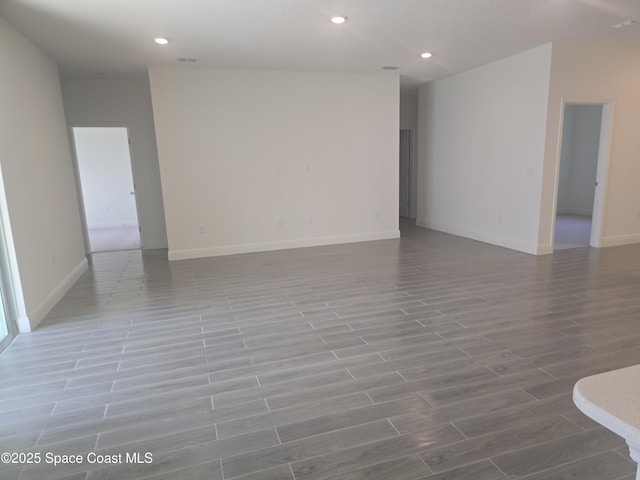 empty room with visible vents, recessed lighting, baseboards, and wood finish floors