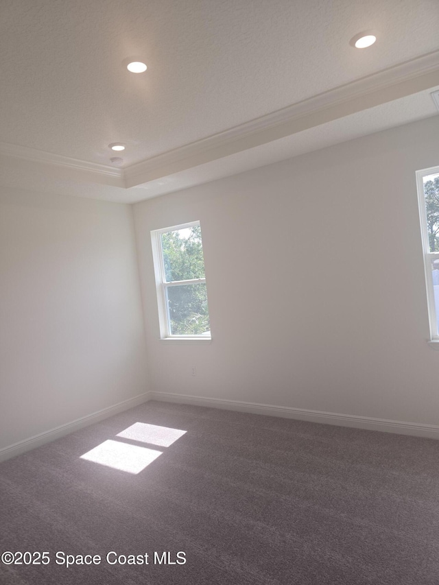 carpeted empty room with recessed lighting, a raised ceiling, and ornamental molding