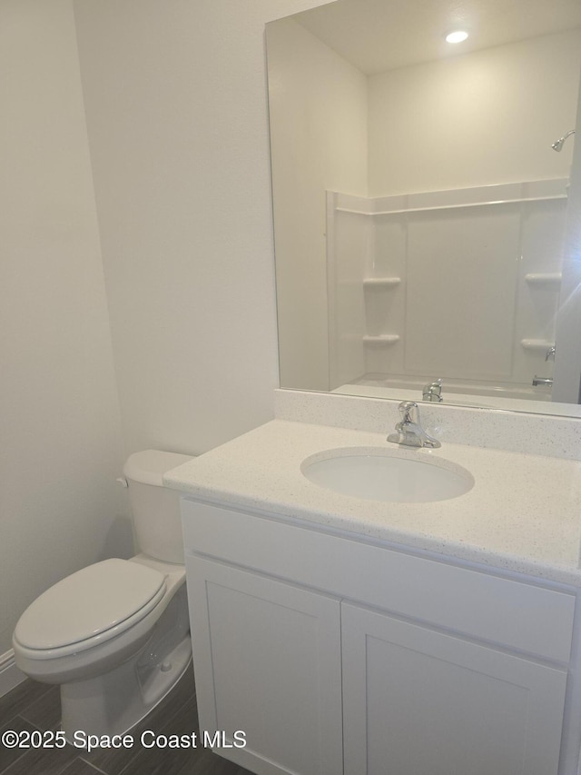 bathroom featuring toilet, vanity, and a shower