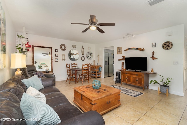 living room featuring light tile patterned flooring, a ceiling fan, visible vents, and baseboards