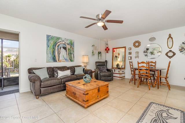 living area featuring light tile patterned flooring, a ceiling fan, and baseboards