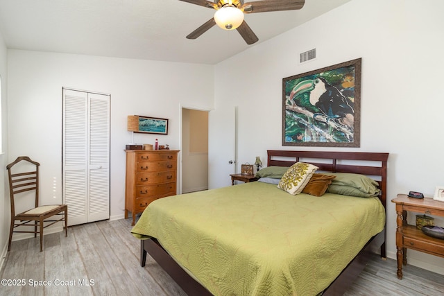 bedroom with ceiling fan, visible vents, a closet, and wood finished floors